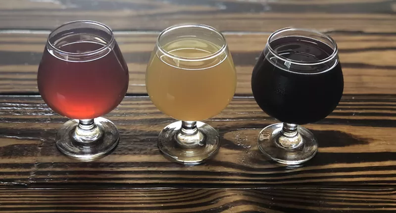 Image: Three packs of strawberry rhubarb pie cider (red), apple pie cider (white), and blueberry pie cider (blue) are available at Cider Corps starting Saturday.