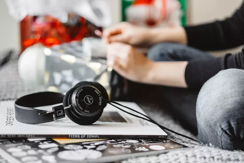 Image: A pair of headphones sitting on a stack of books.