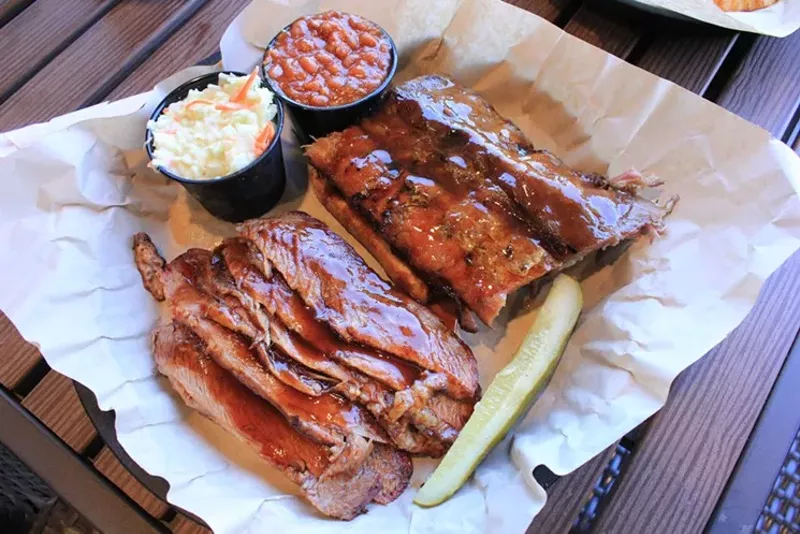 Image: Ribs and brisket smoked over almond wood in West Alley's concrete pit.
