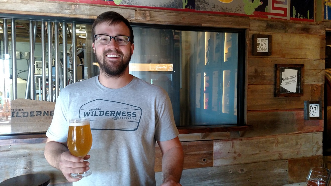 Chase Saraiva, brewer at Arizona Wilderness, hoisting a Tangelo Gose.