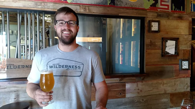 Image: Chase Saraiva, brewer at Arizona Wilderness, hoisting a Tangelo Gose.