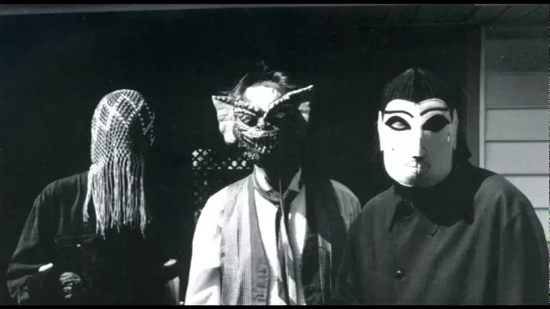 Image: A black and white photo of three people in masks.