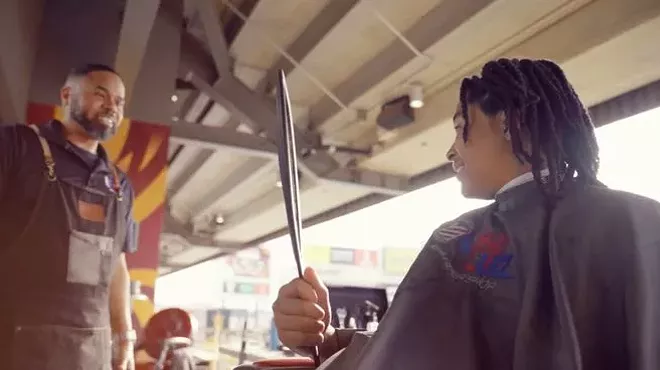 A man giving someone a haircut.