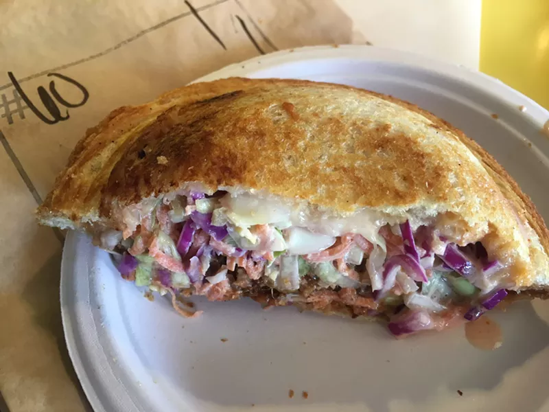 Image: A Zookz stuffed with pulled pork, slaw, and cheese.
