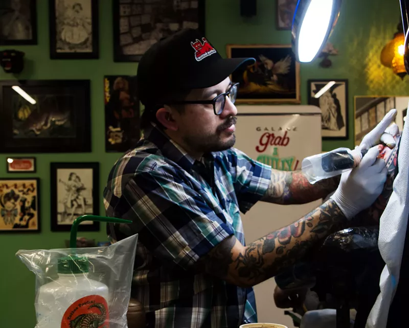Image: Phoenix tattoo artist Paulski works on a client.