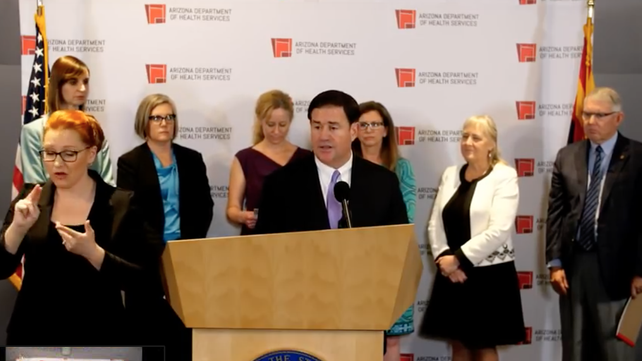 Arizona Governor Doug Ducey, center. Former director of emergency management Wendy Smith-Reeve stands in back, wearing teal.
