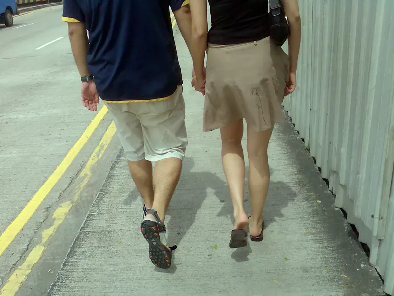 Image: A couple walking down a street.