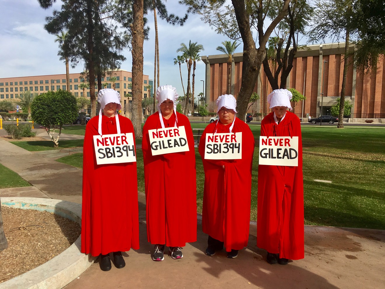 Reproductive rights activists, inspired by The Handmaid's Tale, protest SB 1394 outside the state capitol.
