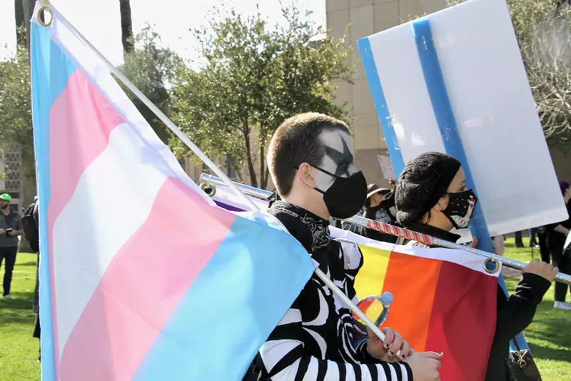 Image: A transgender pride flag is carried during a protest against anti-LGBTQ legislation at the Arizona State Capitol on January 22.