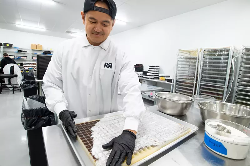 Image: Justin Casino of RR Brothers pours sugar on freshly set gummies.