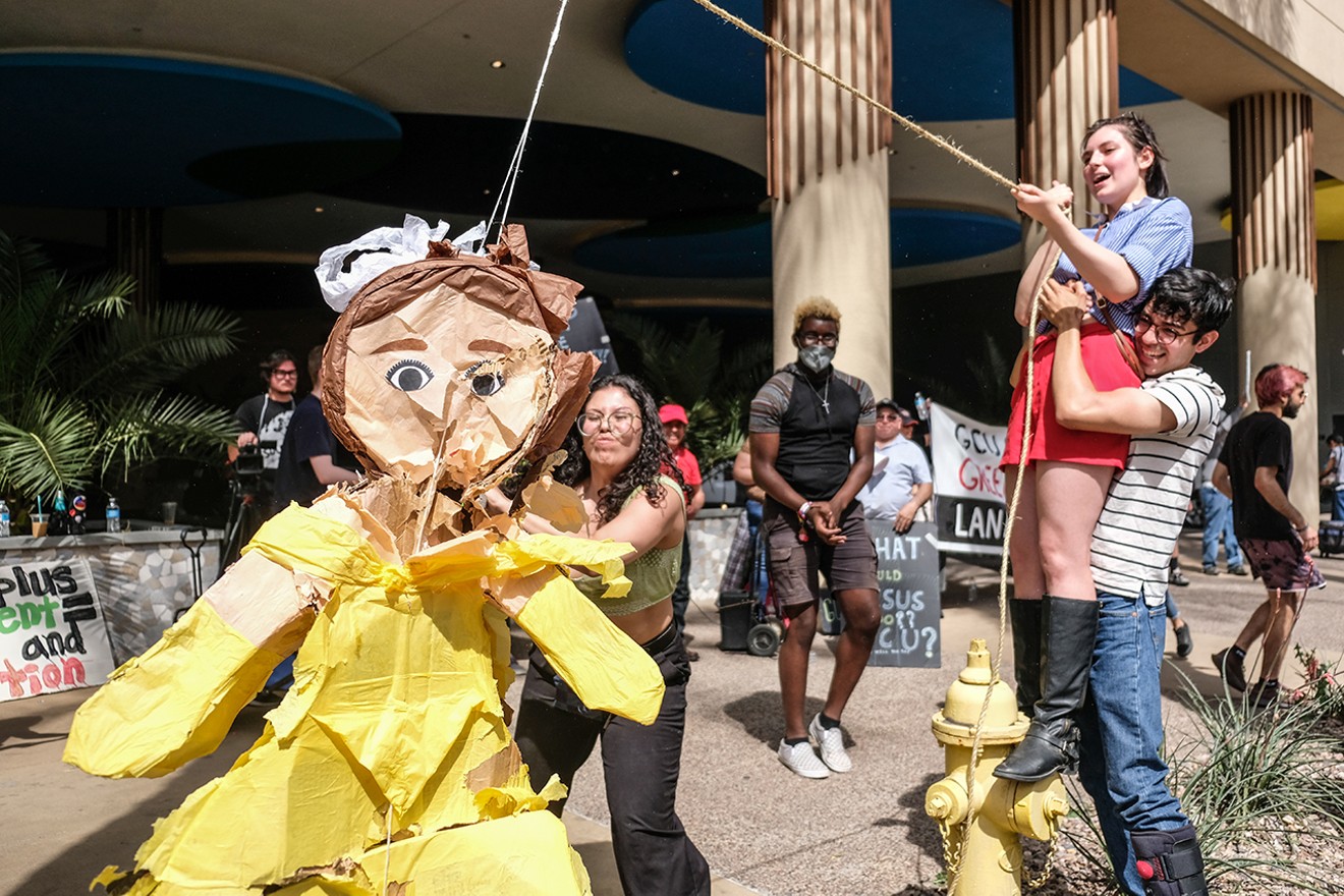 Activists bat a piñata meant to represent Mayor Kate Gallego before her annual State of the City speech on April 12.