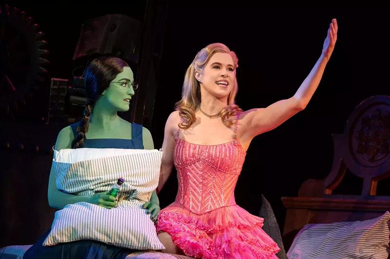 Image: A woman with green skin and a woman in pink dress.