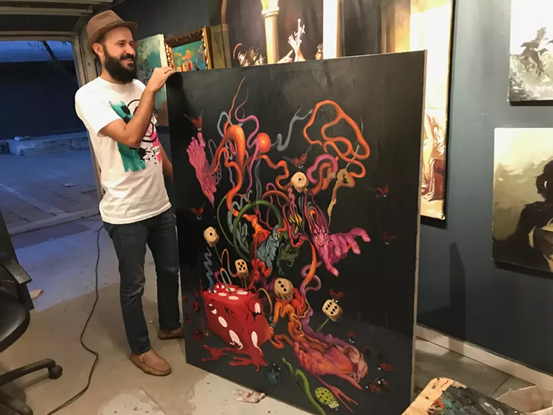 Image: Bassim Al-Shaker with a previous work in progress inside Babylon Gallery.