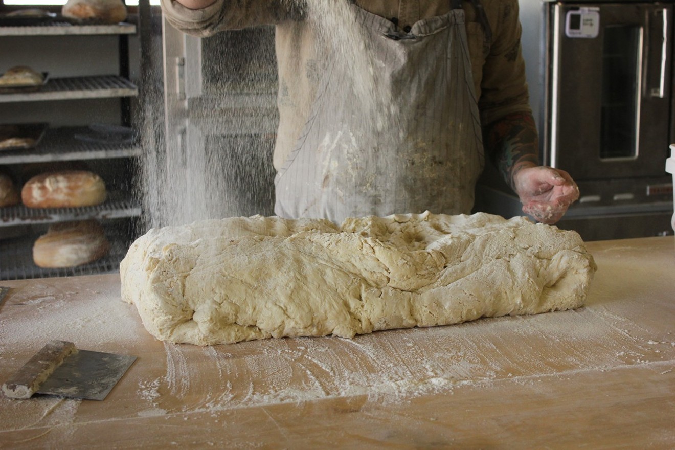 Raining flour onto sourdough dough at Proof Bread.