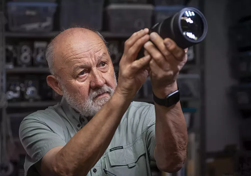 Image: A man looking through a camera.