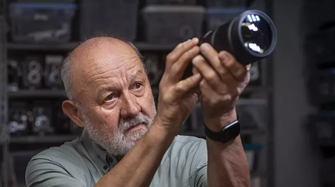A man looking through a camera.
