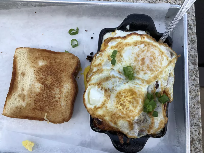 Image: Over-easy eggs, grits, and pulled pork with a side of Texas toast.