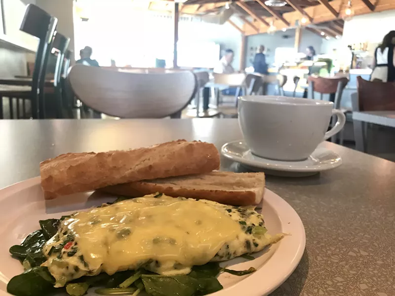 Image: Scrambled eggs and local peppers on a bed of spinach, topped with Dubliner cheddar. As with many Essence dishes, two slices of baguette are served on the side, along with butter, jam, and local honey.