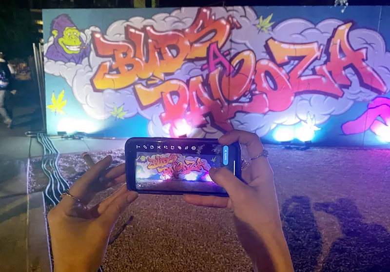 Image: a phone takes a picture of buds-a-palooza graffiti