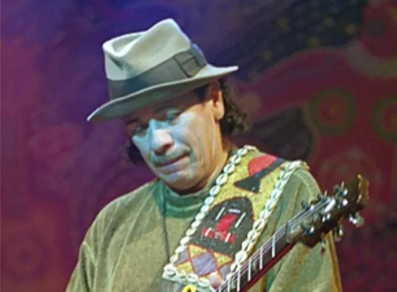 Image: A man in a hat playing guitar.