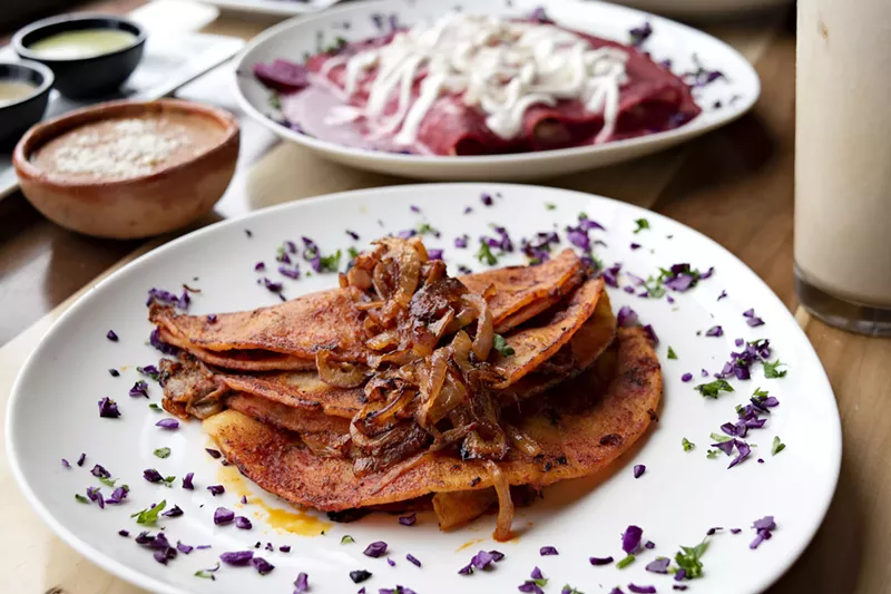 Image: Tacos canasta al vapor with enchiladas in the background.