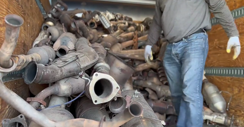Image: Phoenix police officers unload stolen catalytic converters from a self-storage unit in May 2022.