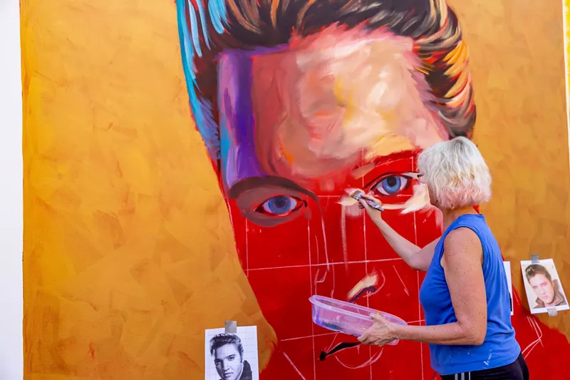 Image: Lucretia Torva works on a musician mural for Tempe Marketplace.