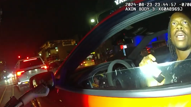 body-cam footage of a flashlight being shined on a man in a car