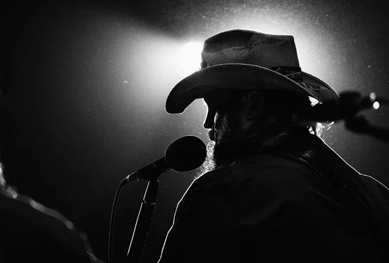Image: A black-and-white photo of a backlit singer.