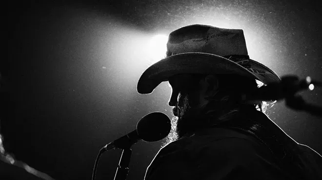 A black-and-white photo of a backlit singer.