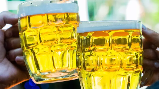Clinking two beer mugs.