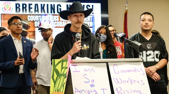 a man in a cowboy hat speaks at a press conference