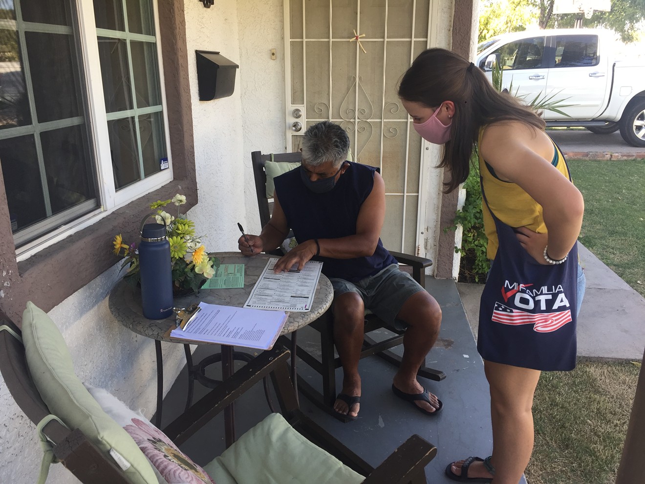 Mi Familia Vota canvasser Alex Robinson helps Phoenix resident Jose Salgado fill out out his ballot