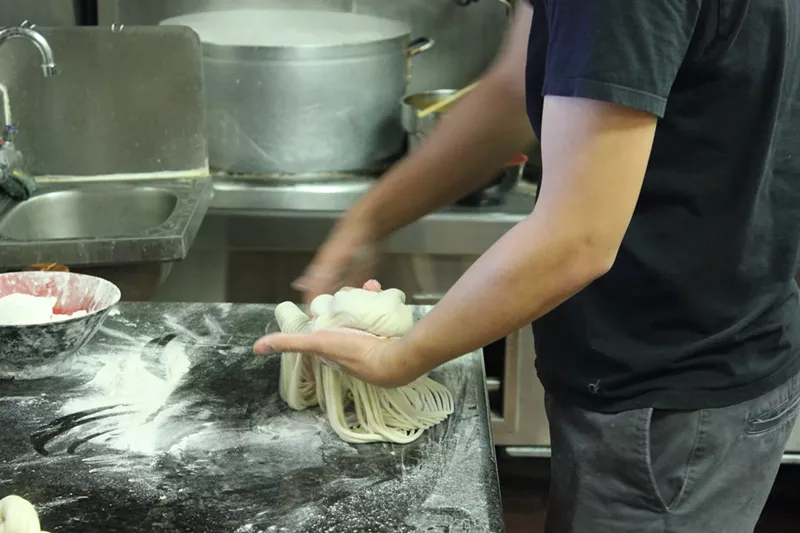 Image: Noodles about to take a brief dip in boiling water.