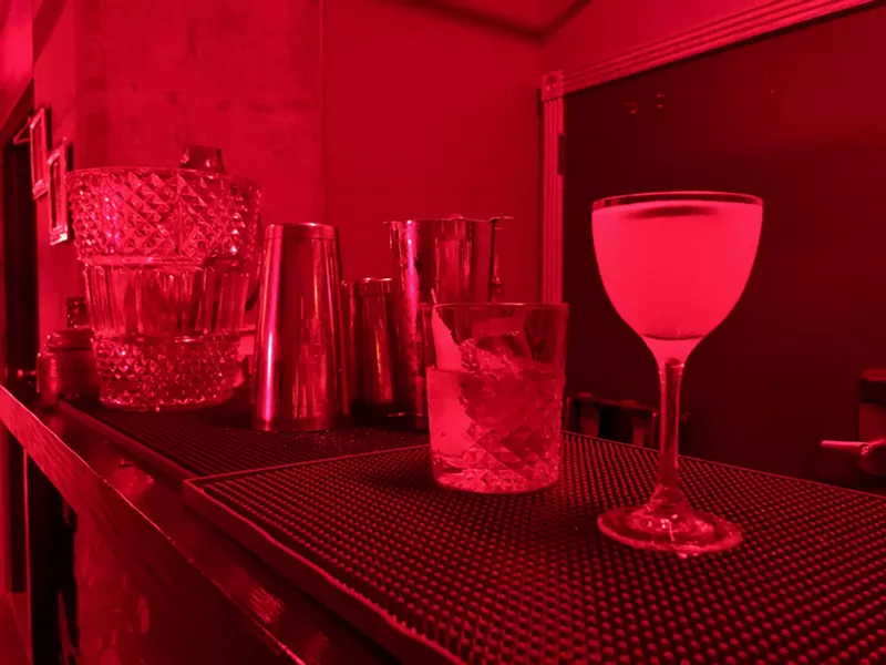 Image: Red light fills the underground bar at Melinda's Alley.