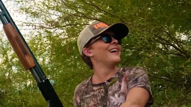 kari lake holding a shotgun while wearing camouflage