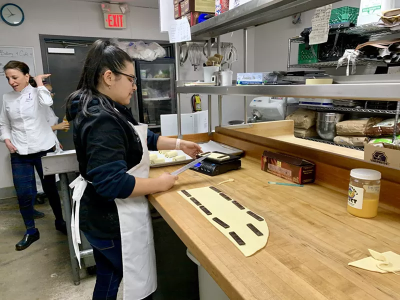 Image: Charlize Cipres working on chocolate croissants (pain au chocolat) at Essence Bakery.