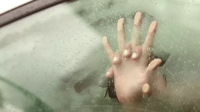 two intertwined hands against a steamy car window