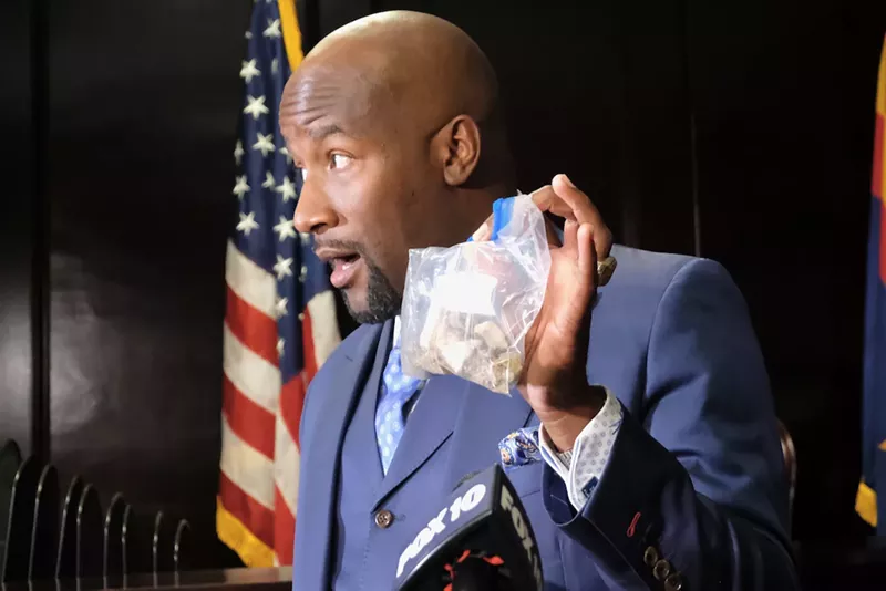 Image: Quacy Smith, an attorney for Osman's family, holds a sample of rocks collected at the scene during a press conference on September 30.