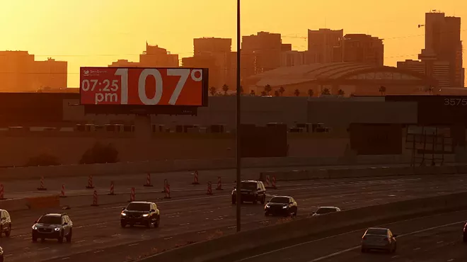 a phoenix highway with a billboard reading 107 degrees at 7:25 p.m.