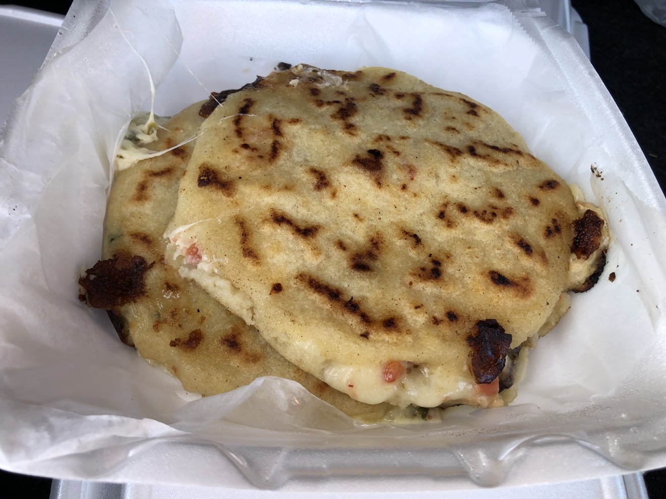 A pair of pupusas hot off the griddle and at their peak.