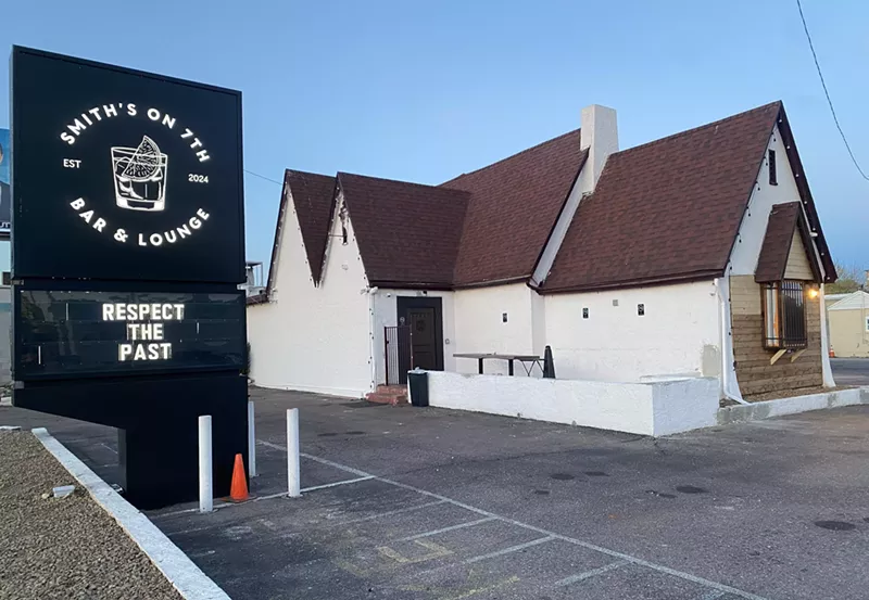 Image: The parking lot and exterior of a former residence that has been converted into a bar.