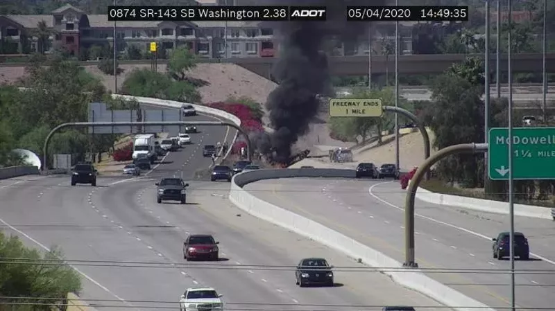 Image: A Garda armored vehicle burns after rolling over on the Loop 202 freeway on Monday. A passenger died in the crash, which is under investigation.