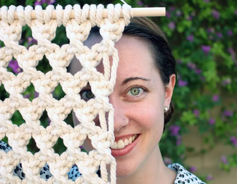 Image: Amy Guerrero with one of her macrame wall hangings.