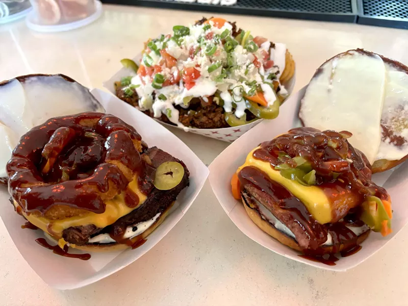 Image: Sidewinder's food menu includes the Big Texan Rodeo (left), chili-topped Sidewinder Fries (back) and the Jalapeno Cheddar Sausage Sando (right).