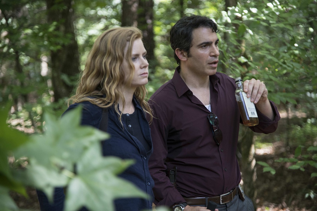 Amy Adams (left) plays Camille Preaker, a journalist for the St. Louis Chronicle with a history of self-harm who encounters a sexy detective (Chris Messina) in HBO's limited series Sharp Objects.