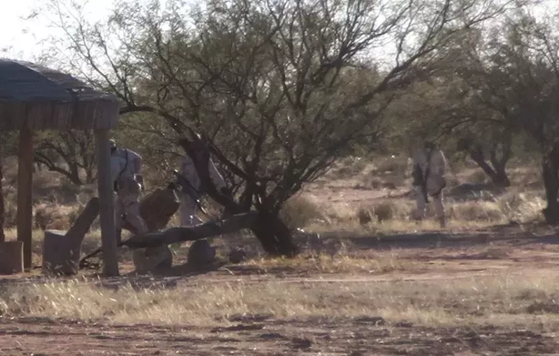 Image: Men dressed in fatigues in Mexico appear to be planting drugs for later pickup by smugglers in this photo taken by New Times from the U.S. side of the border early last year.