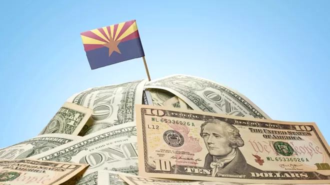 an arizona flag planted in a pile of American currency