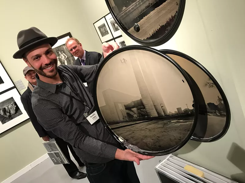 Image: David Emmit Adams, who received a 2015 artist research and development grant from Arizona Commission on the Arts, with his work at "The Photography Show" presented by AIPAD in New York earlier this year.
