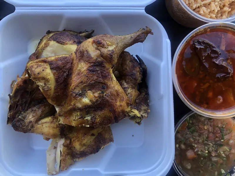 Image: A whole Cuernavaca chicken chopped into parts, plus sides.
